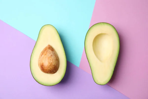 Geschnitten frische reife Avocado auf farbigem Hintergrund, flache Lage — Stockfoto