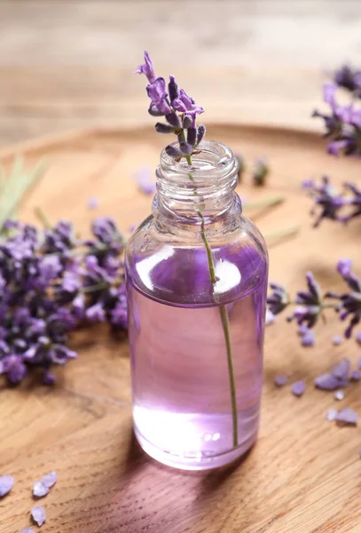 Ahşap tabakta doğal kozmetik yağ ve lavanta çiçekleri Cam şişe — Stok fotoğraf