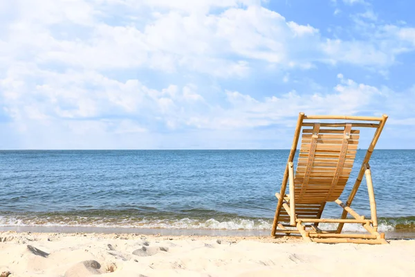 Αμμώδης παραλία με άδειο ξύλινο Σολάριουμ την ηλιόλουστη μέρα — Φωτογραφία Αρχείου