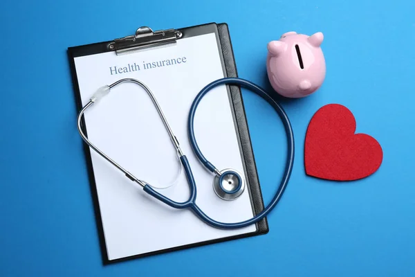 Flat lay composition with health insurance form and stethoscope on blue background — Stock Photo, Image