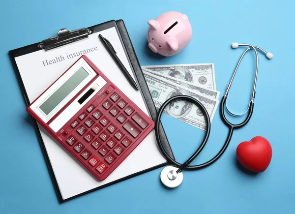 Flat lay composition with health insurance form, calculator and stethoscope on blue background — Stock Photo, Image