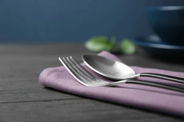 Cutlery set and dishware on dark wooden table