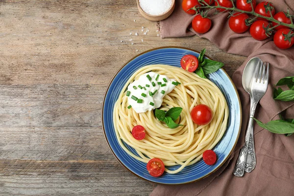 Leckere Spaghetti mit saurer Sahne auf Holztisch serviert, flach gelegt. Raum für Text — Stockfoto