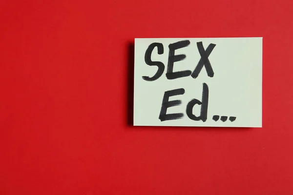 Pappersark med text "sex ED..." på röd bakgrund, uppifrån. Utrymme för text — Stockfoto