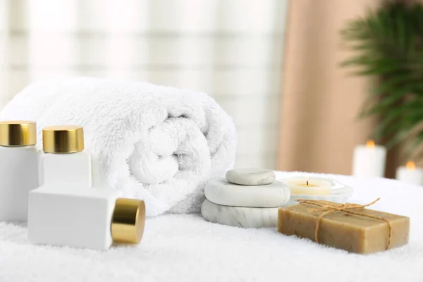 Složení s kosmetickými prostředky na bílém ručníku uvnitř. Lázeňská terapie — Stock fotografie