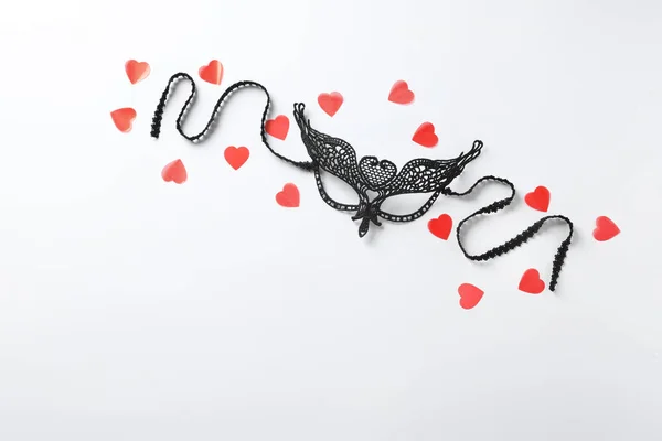 Cinsel rol oynamak için siyah dantel maske ve beyaz arka plan üzerinde kırmızı kalpler — Stok fotoğraf