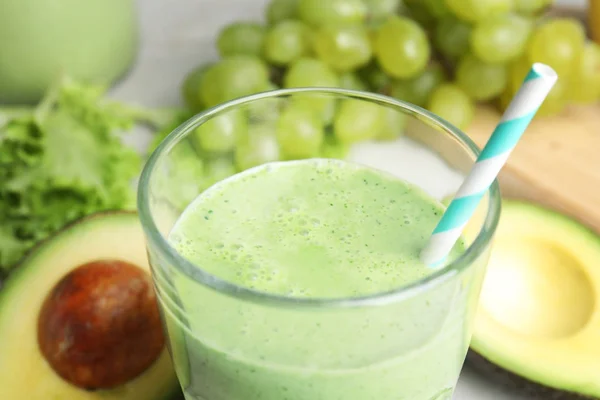 Vaso de sabroso batido de aguacate en la mesa, primer plano —  Fotos de Stock