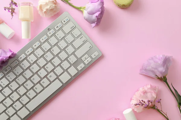 Composición plana con teclado y flores sobre fondo rosa. Lugar de trabajo del blogger de belleza — Foto de Stock