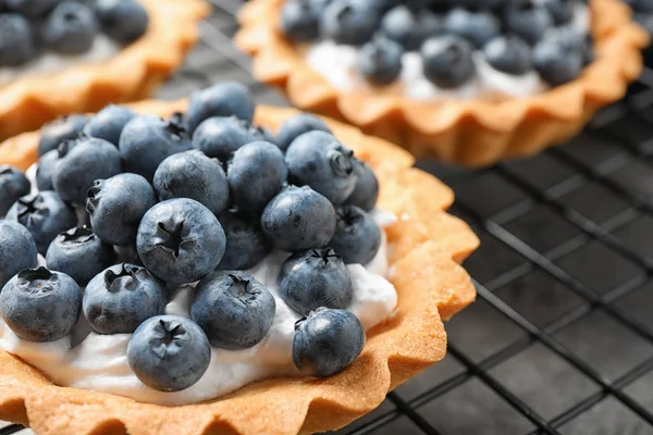 Delicioso doce pastelaria com bagas em rack de refrigeração, close-up — Fotografia de Stock