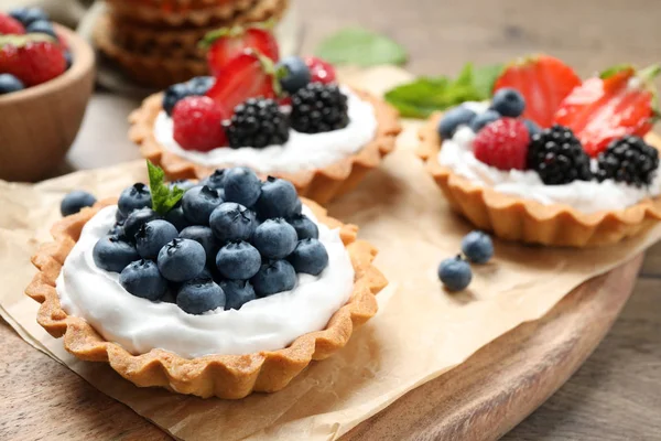 Diferentes tartas de bayas en mesa de madera. Deliciosos pasteles — Foto de Stock