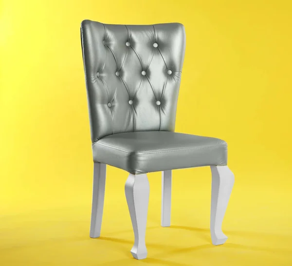 Стильный серебряный стул на желтом фоне, место для текста. Элемент дизайна интерьера — стоковое фото