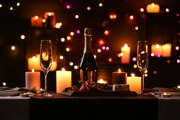 Cena romántica con velas encendidas y luces festivas —  Fotos de Stock