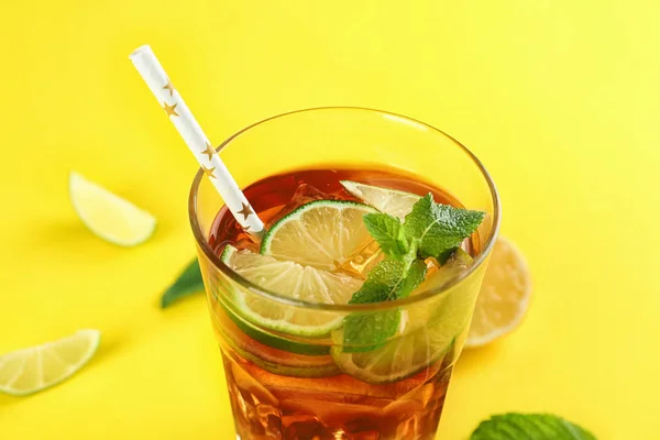 Glass of refreshing iced tea on yellow background — Stock Photo, Image