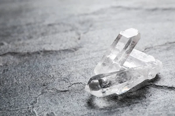 Hermosas piedras preciosas de cristal de roca en la mesa gris, espacio para el texto —  Fotos de Stock