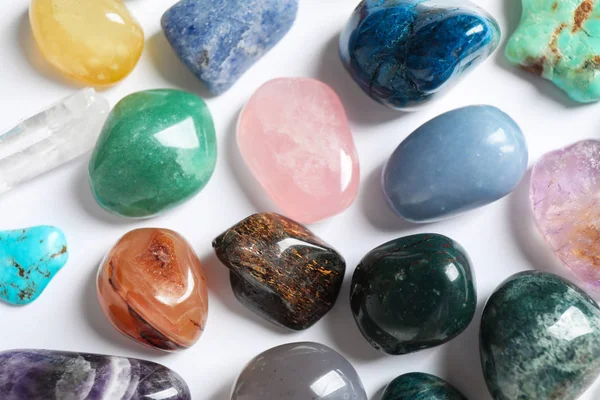 Diferentes pedras preciosas bonitas no fundo branco, vista superior — Fotografia de Stock