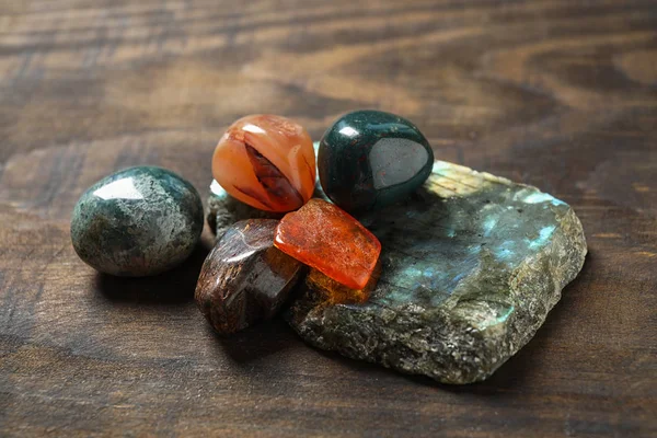Diferentes hermosas piedras preciosas en mesa de madera texturizada — Foto de Stock