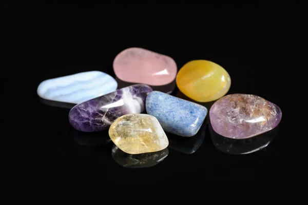 Pilha de diferentes belas pedras preciosas no fundo preto — Fotografia de Stock