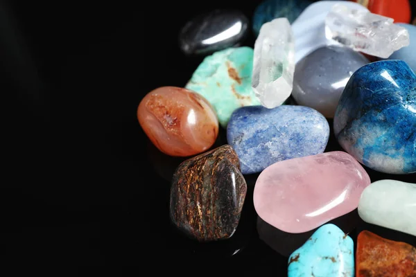 Different beautiful gemstones on black background, closeup. Space for text — Stock Photo, Image