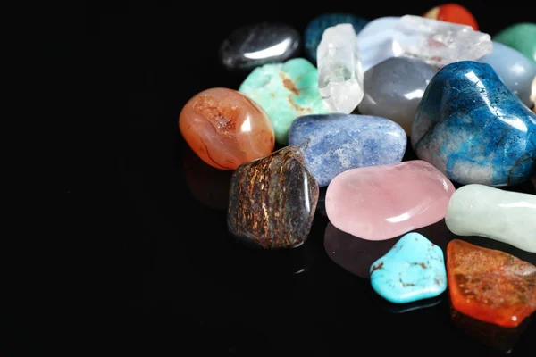 Diferentes pedras preciosas bonitas no fundo preto, close-up. Espaço para texto — Fotografia de Stock