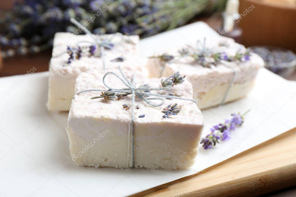 Hand made soap bars with lavender flowers on white paper, closeup