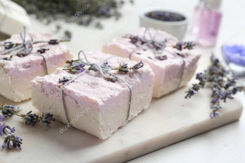 Hand made soap bars with lavender flowers on cutting board, closeup