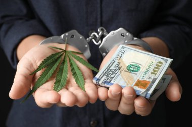 Kelepçeli kadın kenevir yaprağı ve dolar tutan, closeup