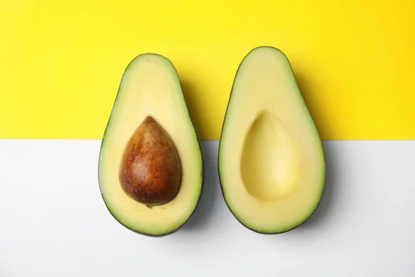 Geschnitten frische reife Avocado auf farbigem Hintergrund, flache Lage — Stockfoto