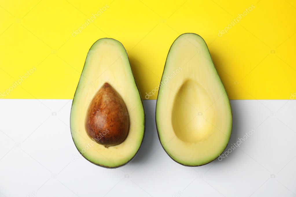 Cut fresh ripe avocado on color background, flat lay