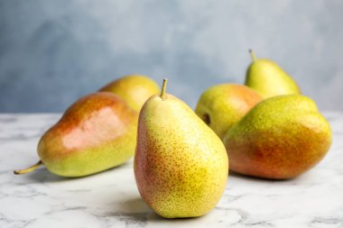 Mavi arka plan karşı mermer masada olgun sulu armut