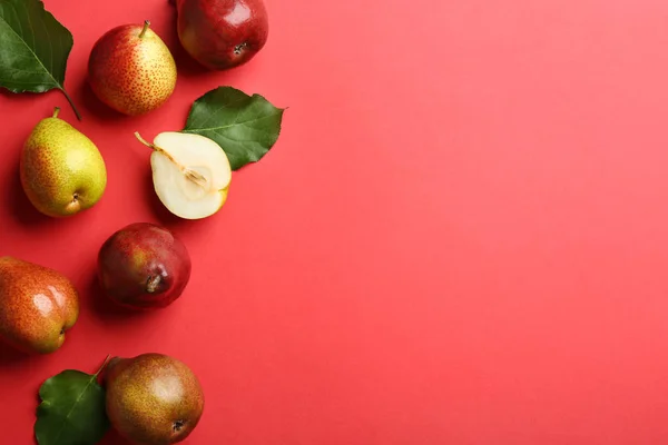 Peras jugosas maduras sobre fondo rojo, planas. Espacio para texto —  Fotos de Stock