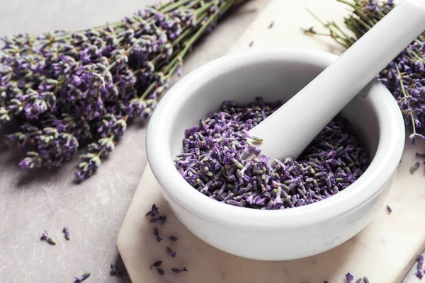 Mortero y mortero con flores de lavanda sobre fondo de piedra gris, espacio para texto. Cosmética natural —  Fotos de Stock