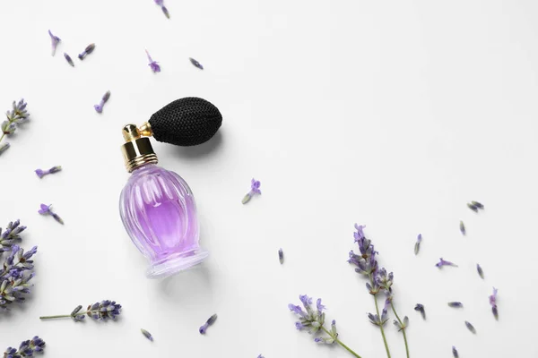 Butelka naturalnych perfum i kwiatów lawendy na białym tle, widok z góry. Produkt kosmetyczny — Zdjęcie stockowe