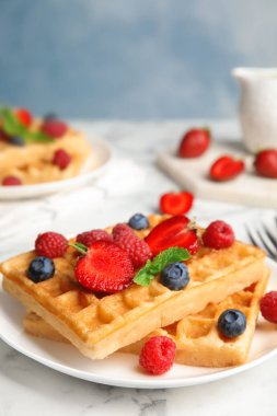 Beyaz mermer masada servis edilen taze çilek ile lezzetli waffle