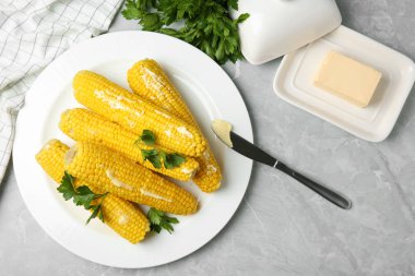 Açık gri mermer masa üzerinde haşlanmış mısır koçanlarının düz döşeme kompozisyonu