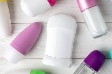 Beyaz ahşap masa üzerinde farklı deodorantlar ile düz döşeme kompozisyon