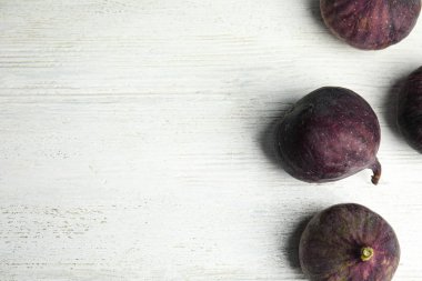 Beyaz ahşap masa üzerinde lezzetli olgun incir, düz yatıyordu. Metin için alan