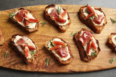 Krem peynir, prosciutto ve incir ahşap tahta, üst görünümü servis ile Bruschettas