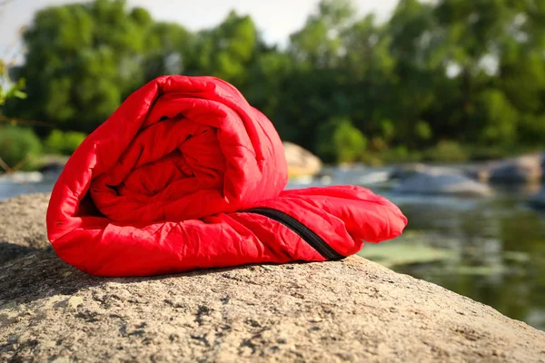Bolso de dormir enrollado cerca del lago en un día soleado — Foto de Stock