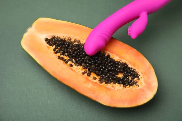 Mitad de papaya y vibrador morado sobre fondo gris oscuro, vista superior. Concepto de sexo — Foto de Stock