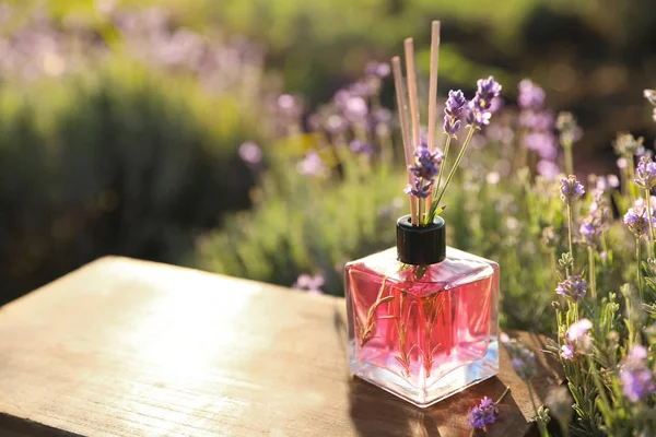 꽃밭에 나무 테이블에 기름과 신선한 라벤더 꽃 갈대 공기 청정기. 텍스트를 위한 공간 — 스톡 사진