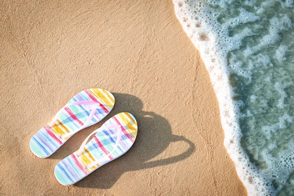 Infradito alla moda sulla sabbia vicino al mare, vista dall'alto con spazio per il testo. Accessori da spiaggia — Foto Stock