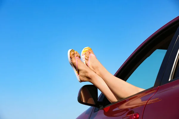 Närbild av kvinna som visar benen med flip flops från bil, utrymme för text. Strandtillbehör — Stockfoto