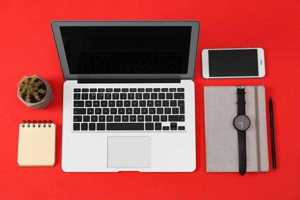 Platt Lay sammansättning med moderna enheter och Office-verktyg på röd bakgrund — Stockfoto