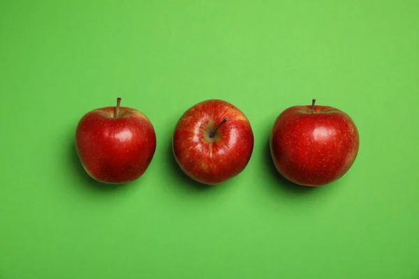 Composición plana con manzanas rojas jugosas maduras sobre fondo verde — Foto de Stock
