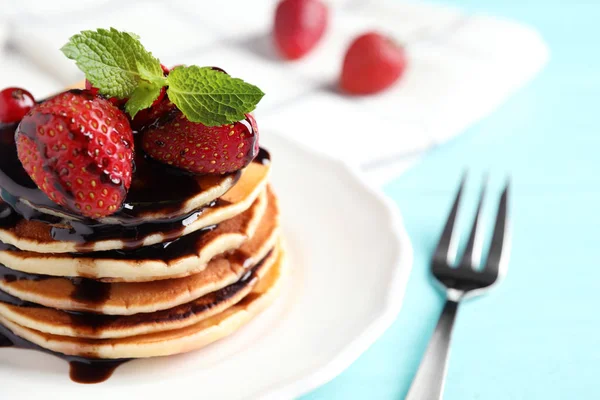 Délicieuses crêpes aux fraises fraîches et sirop de chocolat sur table en bois bleu clair, gros plan — Photo