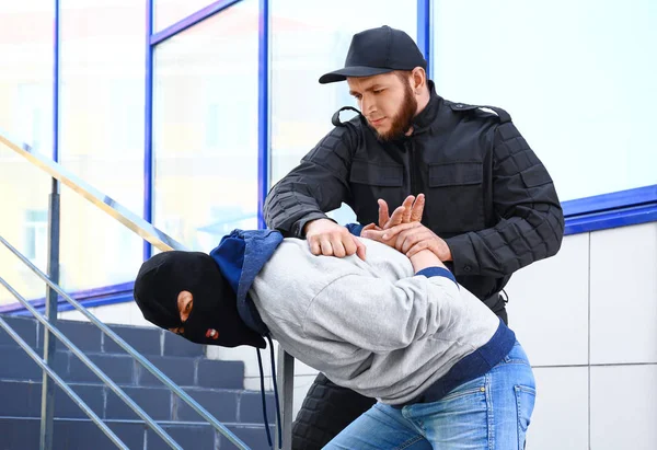 Politieagent arresteren gemaskerde crimineel buitenshuis — Stockfoto