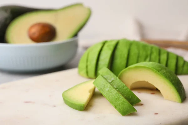 Scheiben frischer Avocado auf Steinplatten — Stockfoto