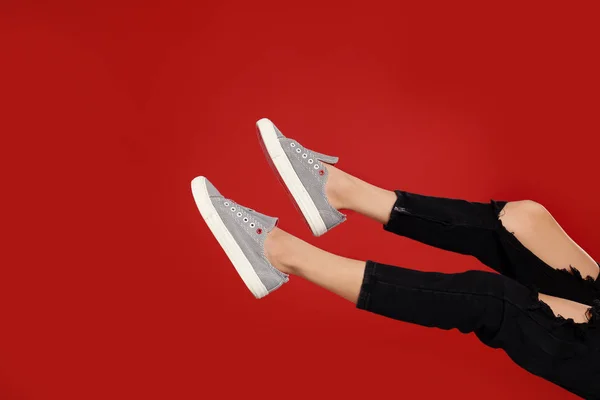 Mujer en zapatos deportivos con estilo sobre fondo rojo —  Fotos de Stock