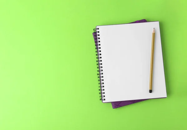 Notebooks with pencil on light green background, top view. Space for text — Stock Photo, Image