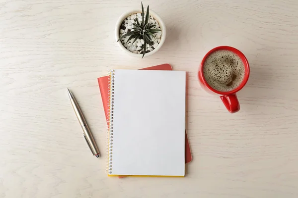 Composição de leigos plana com papelaria de escritório e xícara de café na mesa de madeira branca. Espaço para design — Fotografia de Stock